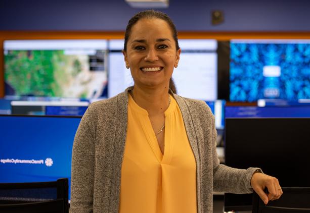 Tauty Sanchez wearing a yellow shirt facing the camera standing inside the IT Center of Excellence at Pima. 